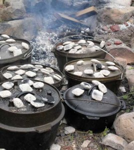 Dutch oven cooking taken to a great extent, six dutch ovens in a fire ring.
