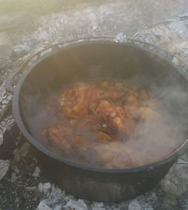 A dutch oven meal made up of chicken and potatoes